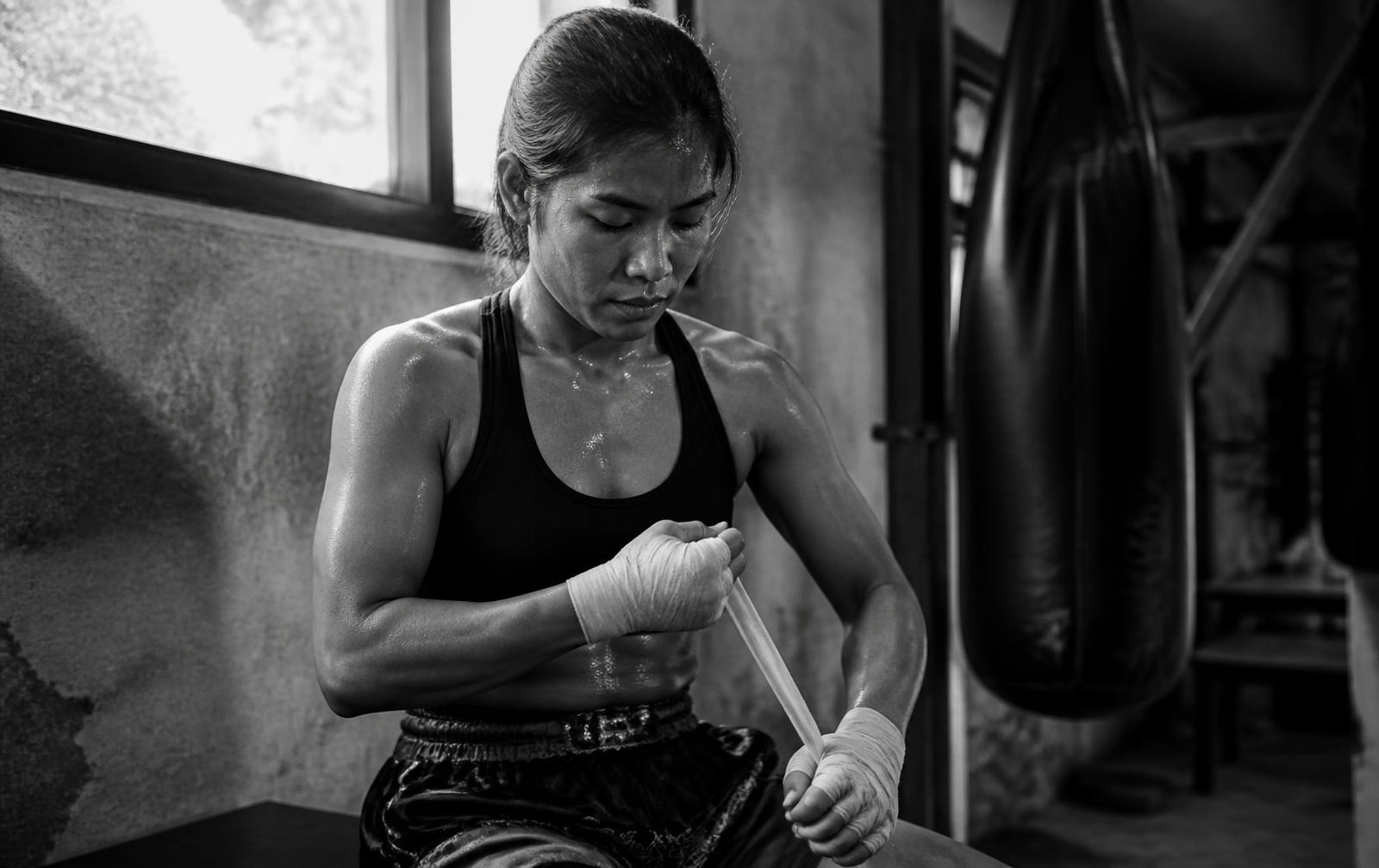 A fighter wrapping her hands before training